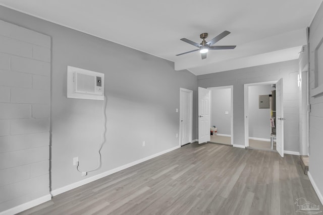 unfurnished bedroom with light hardwood / wood-style floors, ceiling fan, and an AC wall unit