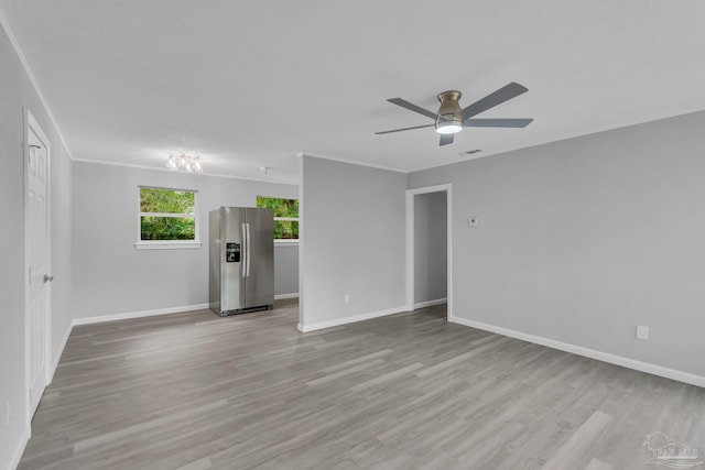 empty room with light hardwood / wood-style floors, ceiling fan, and crown molding