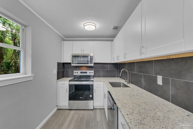 kitchen featuring white cabinets, sink, light hardwood / wood-style floors, and stainless steel appliances