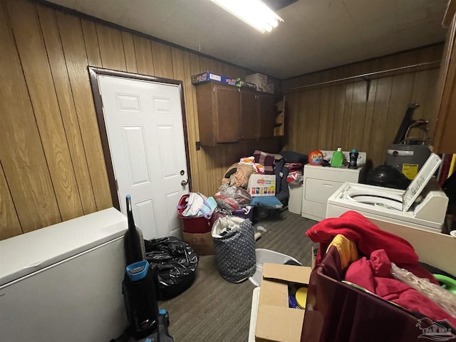 laundry area with wood walls and washing machine and clothes dryer