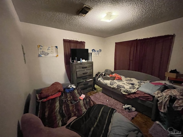 carpeted bedroom featuring a textured ceiling