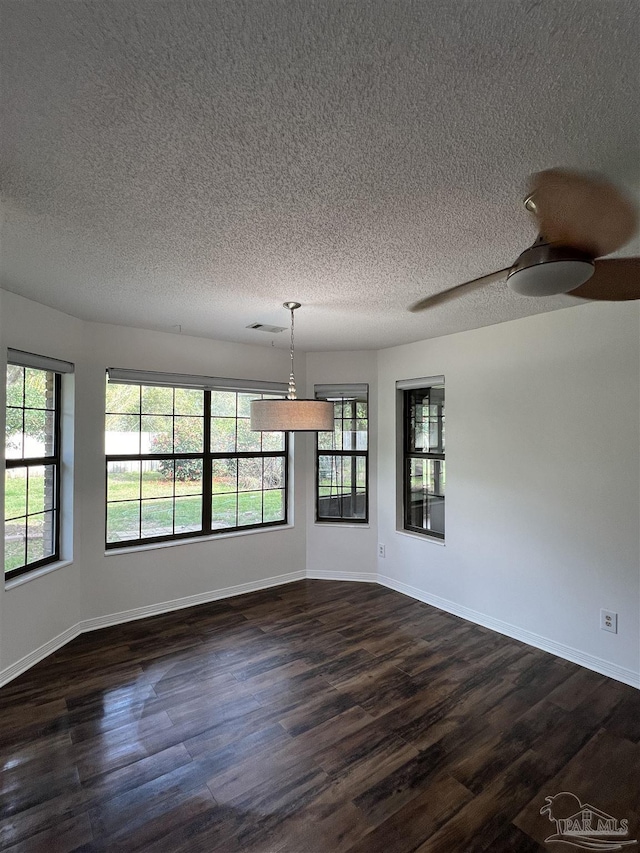 unfurnished dining area featuring dark wood-style floors, visible vents, and baseboards