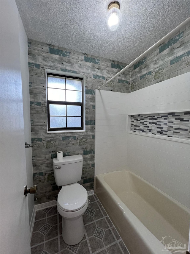 bathroom with tile patterned flooring, a textured ceiling, and toilet