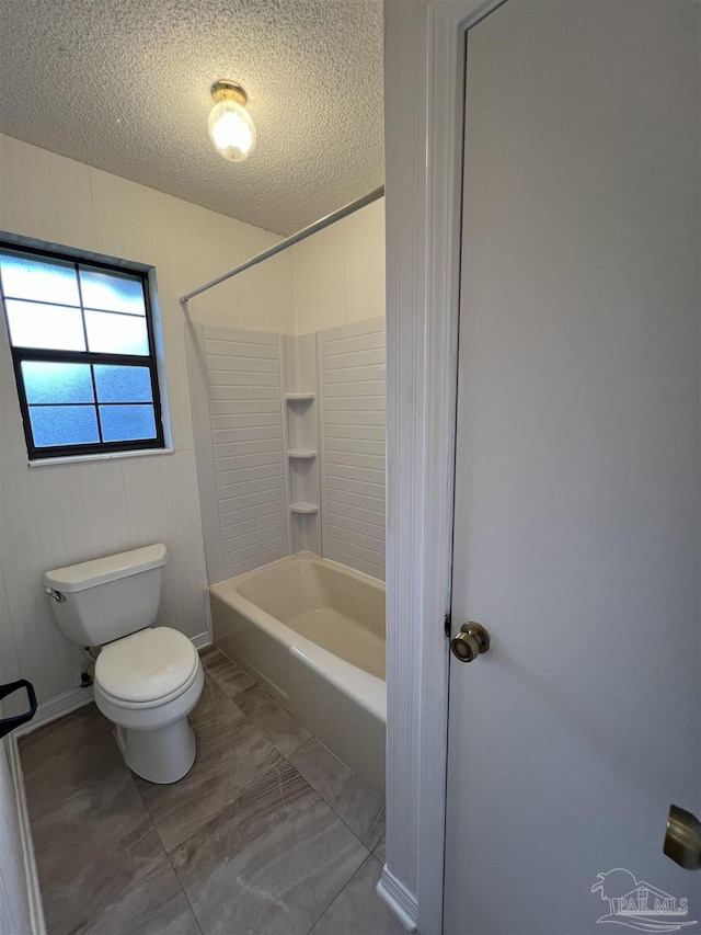 full bath featuring toilet, bathtub / shower combination, and a textured ceiling