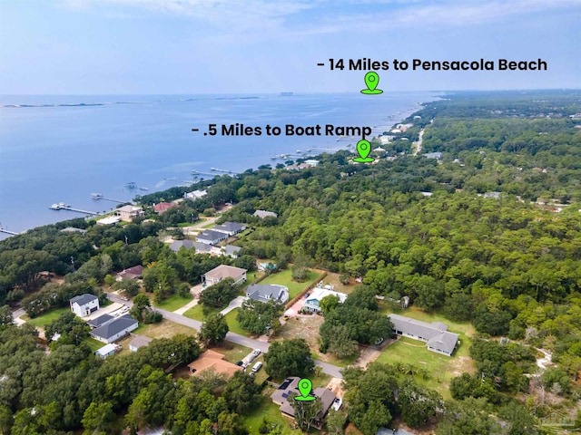 drone / aerial view featuring a water view and a wooded view