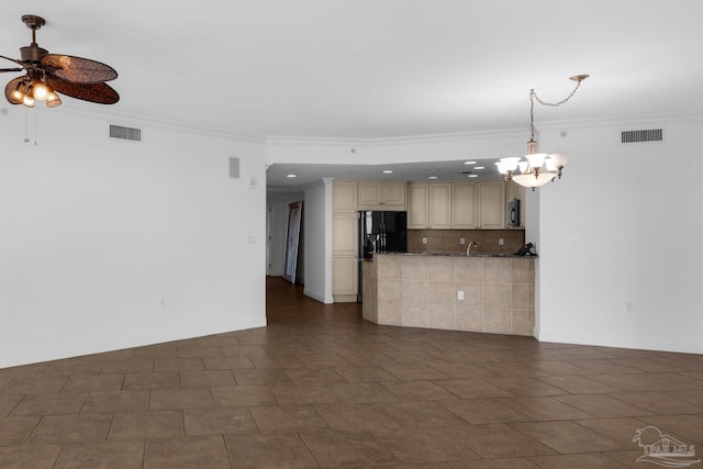 unfurnished living room with ceiling fan with notable chandelier and crown molding