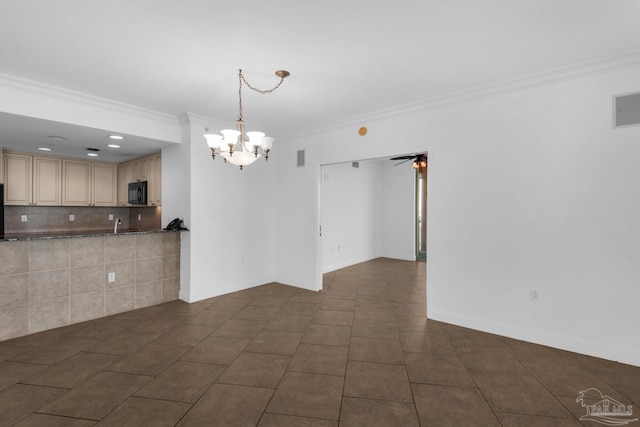 unfurnished room with ceiling fan with notable chandelier, ornamental molding, and dark tile patterned flooring