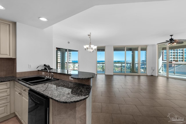 kitchen featuring sink, dishwasher, kitchen peninsula, hanging light fixtures, and dark stone counters