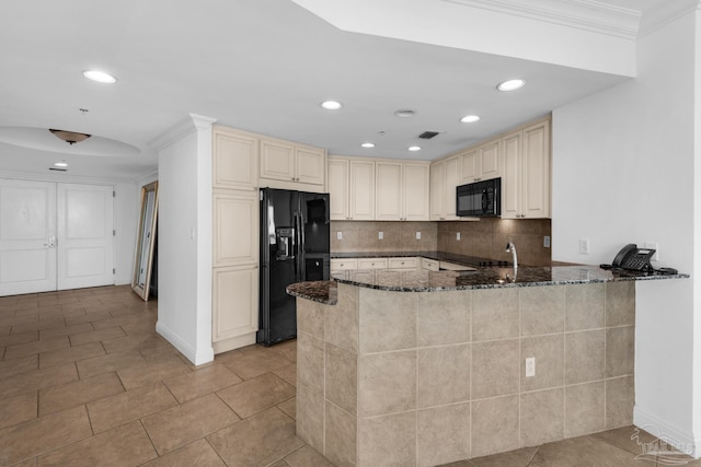 kitchen featuring dark stone countertops, black appliances, and kitchen peninsula