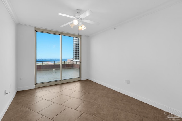 tiled empty room with ornamental molding, ceiling fan, and a water view