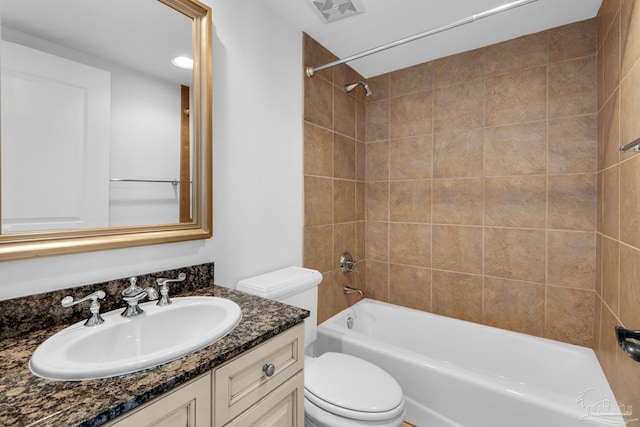 full bathroom with tiled shower / bath, vanity, and toilet