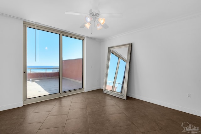 empty room with ceiling fan, dark tile patterned floors, and crown molding