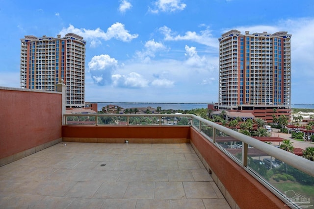 view of patio / terrace with a balcony and a water view