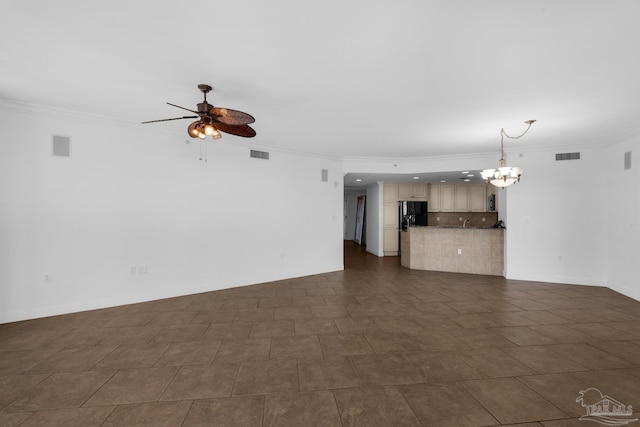 unfurnished living room featuring ceiling fan with notable chandelier and ornamental molding