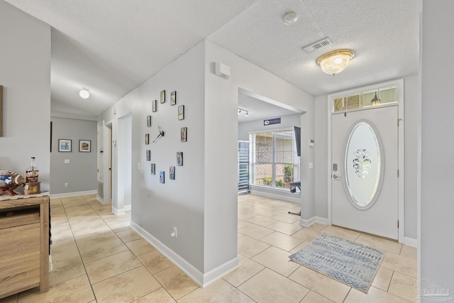 1307 Mazurek Blvd, Pensacola, FL 32514 - entrance foyer featuring light tile patterned floors, a textured ceiling, lofted ceiling, and baseboards