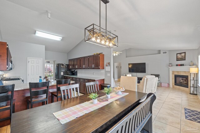 1307 Mazurek Blvd, Pensacola, FL 32514 - dining room featuring vaulted ceiling, light tile patterned floors, a tiled fireplace, and a ceiling fan