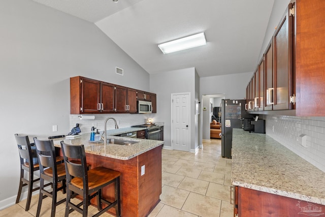 1307 Mazurek Blvd, Pensacola, FL 32514 - kitchen featuring stainless steel appliances, a sink, a peninsula, tasteful backsplash, and light stone countertops
