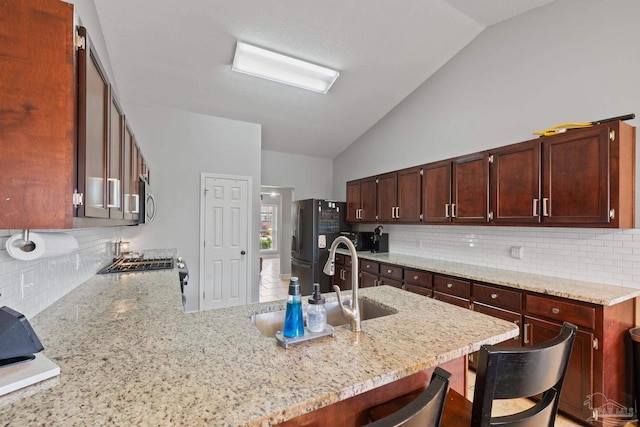 1307 Mazurek Blvd, Pensacola, FL 32514 - kitchen featuring stainless steel appliances, lofted ceiling, a sink, decorative backsplash, and a breakfast bar area