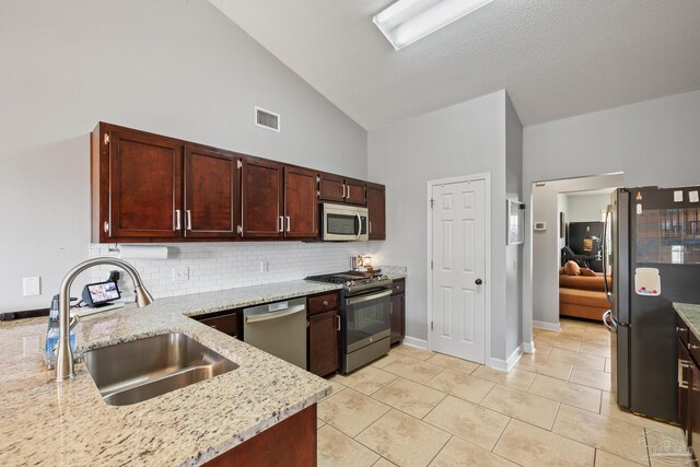 1307 Mazurek Blvd, Pensacola, FL 32514 - kitchen with stainless steel appliances, a sink, high vaulted ceiling, light stone countertops, and tasteful backsplash