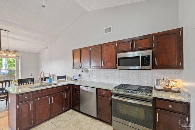 1307 Mazurek Blvd, Pensacola, FL 32514 - kitchen with stainless steel appliances, a sink, vaulted ceiling, a peninsula, and decorative backsplash
