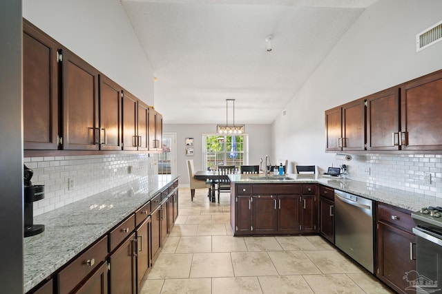 1307 Mazurek Blvd, Pensacola, FL 32514 - kitchen featuring appliances with stainless steel finishes, a sink, a peninsula, backsplash, and light stone countertops