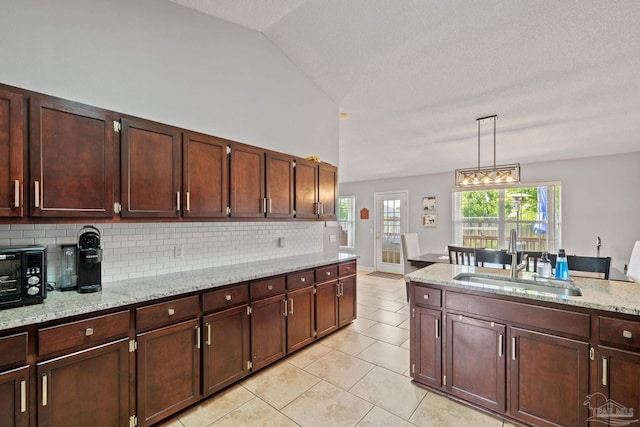 1307 Mazurek Blvd, Pensacola, FL 32514 - kitchen featuring a sink, decorative backsplash, light tile patterned floors, hanging light fixtures, and light stone countertops