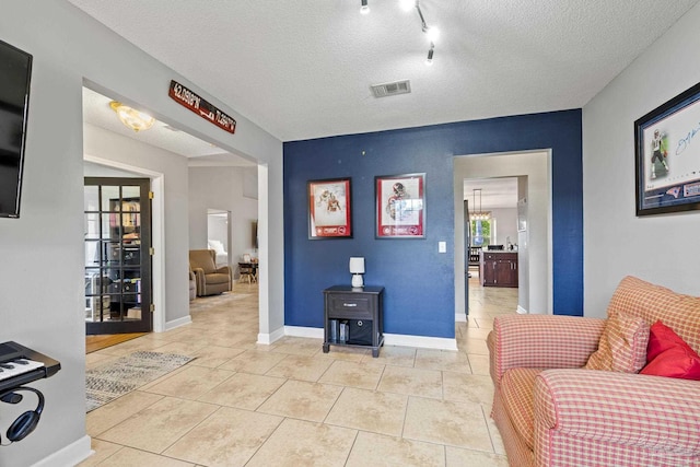 1307 Mazurek Blvd, Pensacola, FL 32514 - sitting room featuring baseboards, light tile patterned flooring, a textured ceiling, and track lighting