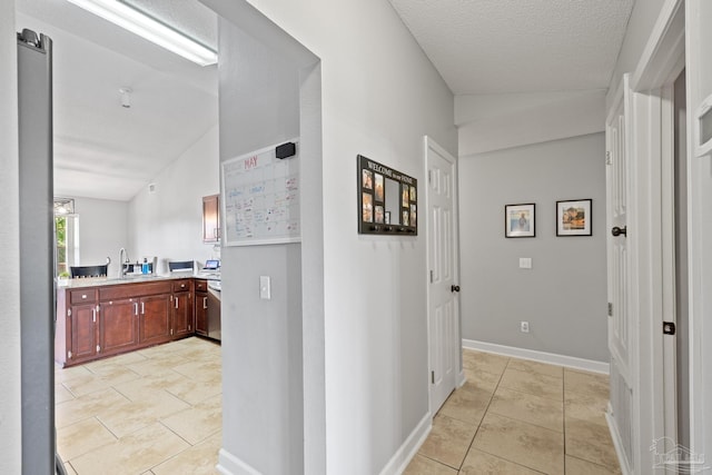 1307 Mazurek Blvd, Pensacola, FL 32514 - corridor with light tile patterned floors, a sink, baseboards, and a textured ceiling