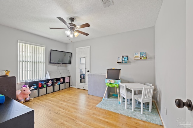 1307 Mazurek Blvd, Pensacola, FL 32514 - playroom featuring a ceiling fan, a textured ceiling, wood finished floors, and baseboards