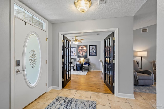 1307 Mazurek Blvd, Pensacola, FL 32514 - entryway featuring french doors, light tile patterned floors, a textured ceiling, baseboards, and a ceiling fan