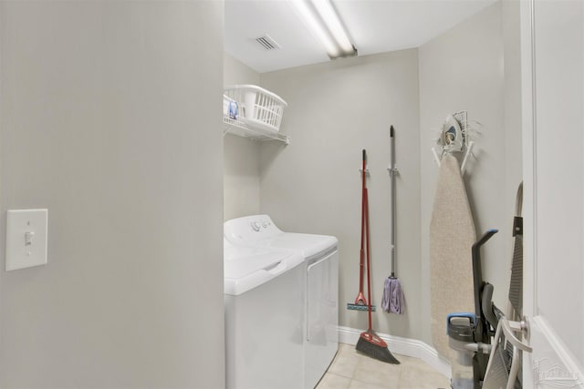 laundry area with light tile patterned floors and washing machine and clothes dryer