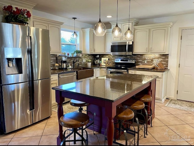 kitchen featuring stainless steel appliances, light tile patterned flooring, and a kitchen bar