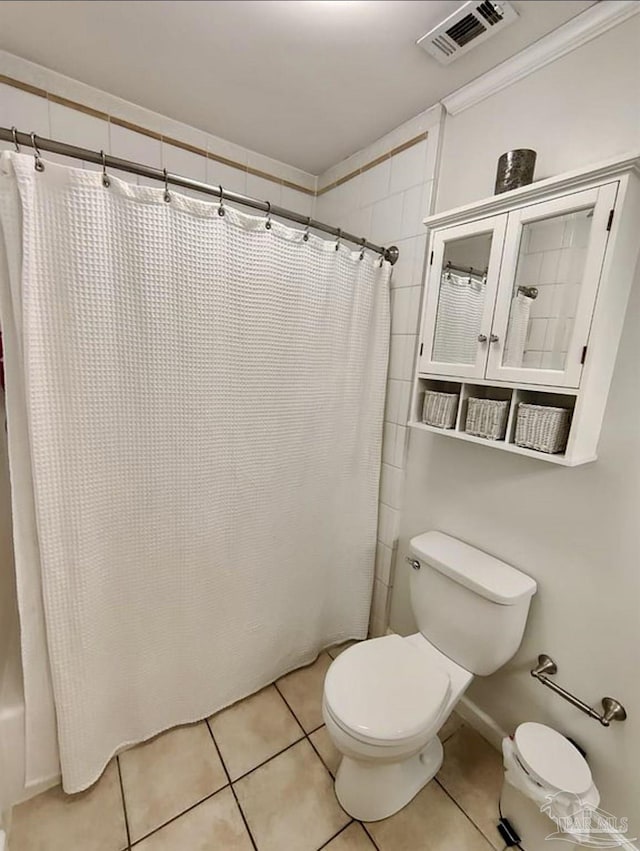 bathroom with toilet, a shower with shower curtain, visible vents, baseboards, and tile patterned floors