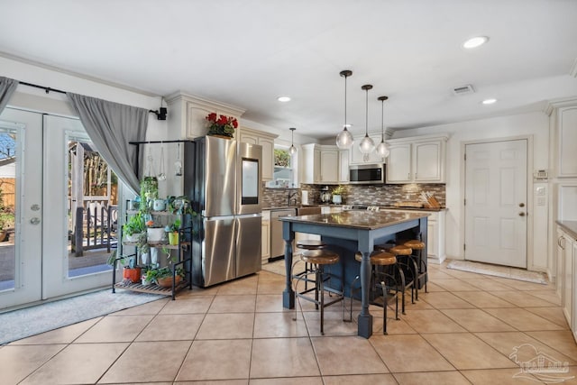 kitchen featuring light tile patterned floors, stainless steel appliances, french doors, and visible vents