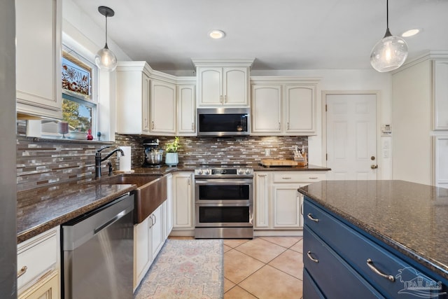 kitchen featuring hanging light fixtures, appliances with stainless steel finishes, decorative backsplash, and blue cabinets