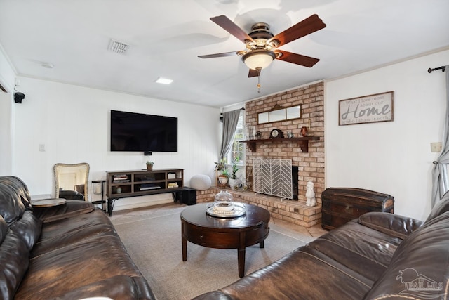 living area featuring a brick fireplace, visible vents, and a ceiling fan