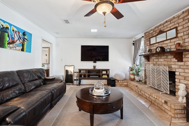 tiled living area featuring a fireplace, visible vents, and a ceiling fan