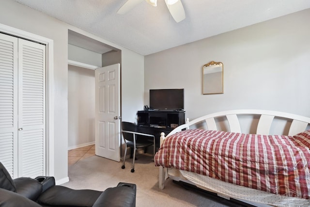 bedroom with ceiling fan, baseboards, a closet, tile patterned floors, and carpet