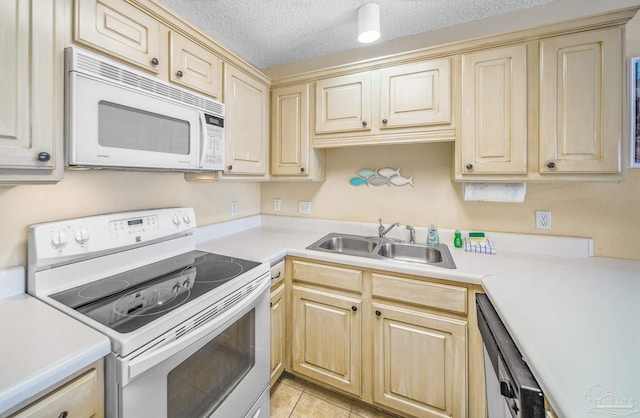 kitchen with white appliances, light countertops, a sink, and a textured ceiling