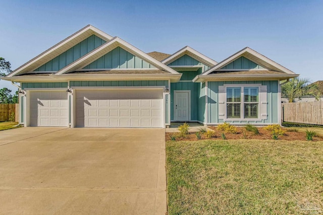 view of front of property with concrete driveway, an attached garage, board and batten siding, a front yard, and fence