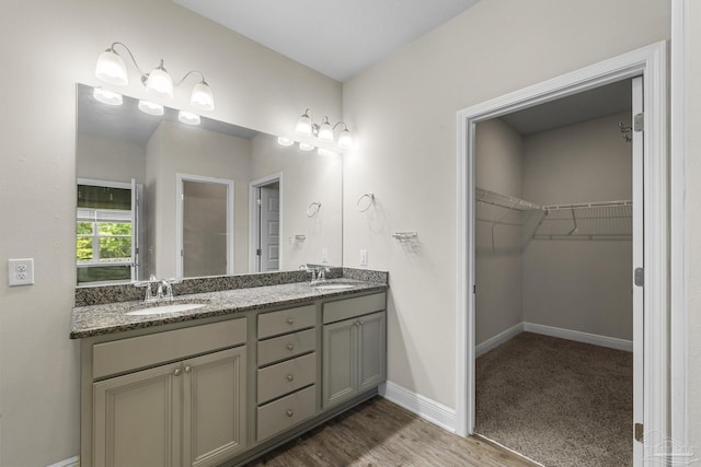 3526 Whitetail Ln, Pensacola, FL 32526 - bathroom with double vanity, a spacious closet, baseboards, and wood finished floors