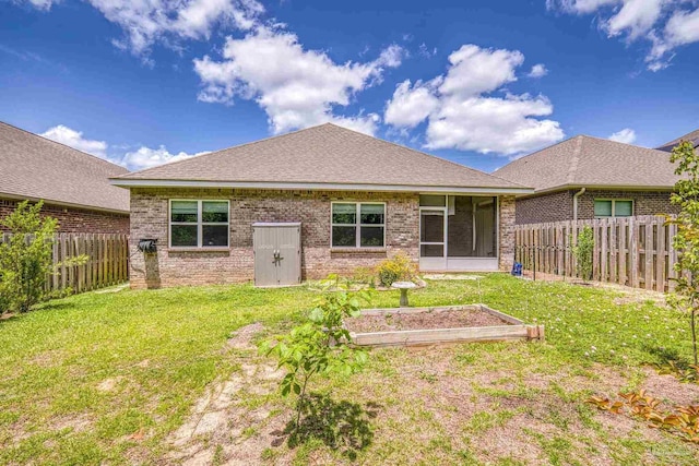 3526 Whitetail Ln, Pensacola, FL 32526 - rear view of property featuring a garden, brick siding, a sunroom, and roof with shingles