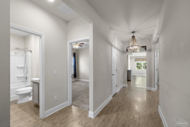 3526 Whitetail Ln, Pensacola, FL 32526 - hall featuring wood finished floors, a chandelier, and baseboards