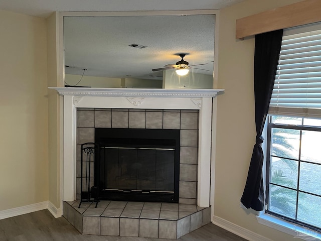 room details featuring hardwood / wood-style floors, a fireplace, a textured ceiling, and ceiling fan