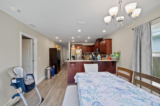 dining space with a chandelier, light wood-style flooring, recessed lighting, visible vents, and baseboards