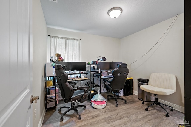 home office featuring baseboards and wood finished floors