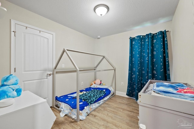 bedroom featuring a textured ceiling and wood finished floors