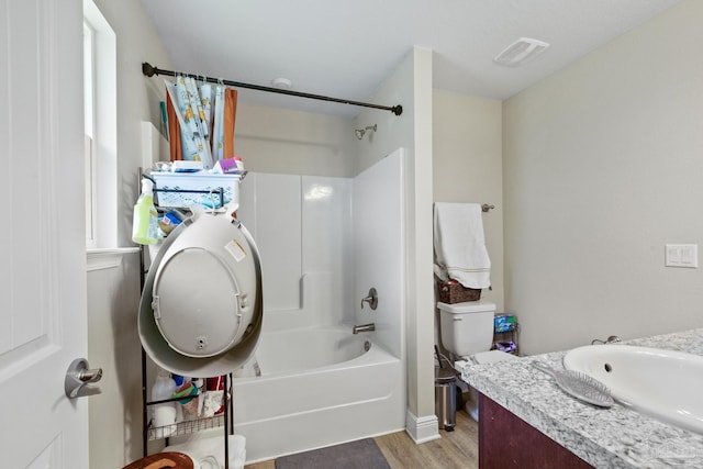 bathroom with shower / washtub combination, visible vents, toilet, vanity, and wood finished floors