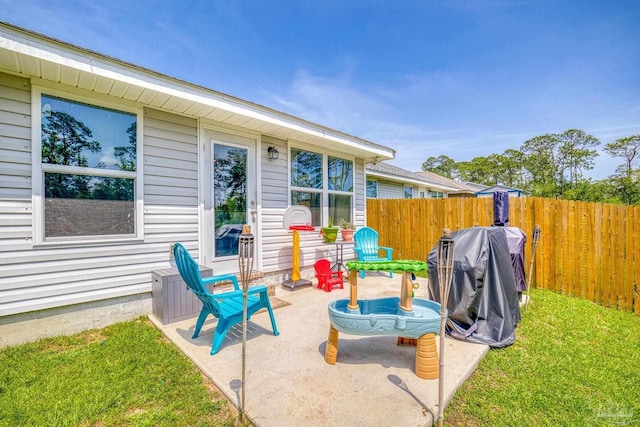 view of patio featuring a grill and fence