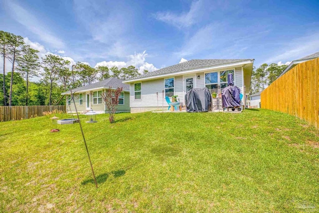 back of house featuring a yard and a fenced backyard